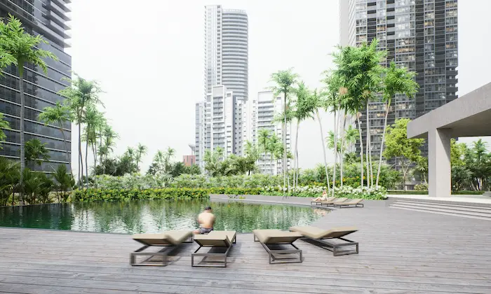 Plataforma de madera sostenible junto a piscina en diseño paisajístico tropical