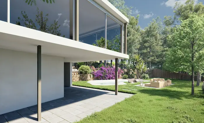 Comedor exterior bajo pérgola rodeado de vegetación mediterránea en vivienda de Vilanova del Vallès