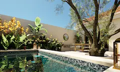 Lounge area with pool and circular mirror designed for arid Southern European climates