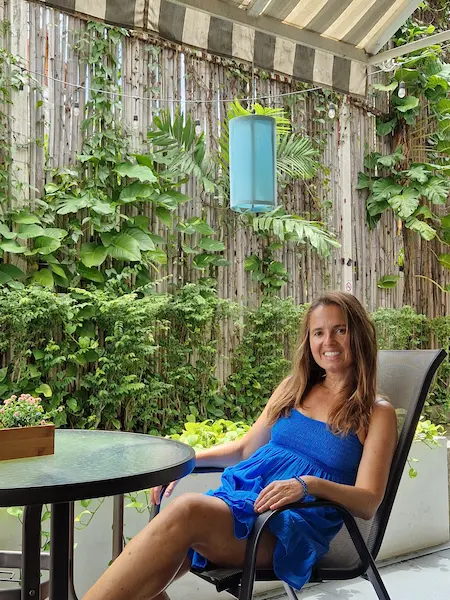 Portrait of landscape designer Kasia Porebska  sitting outdoors beside a lush vertical garden.